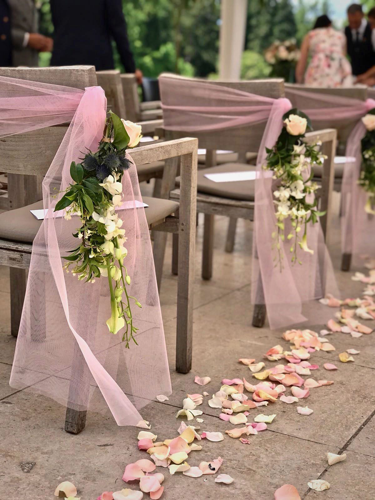 Chaises de cérémonie décorées de tulle et de fleurs, allée de pétales