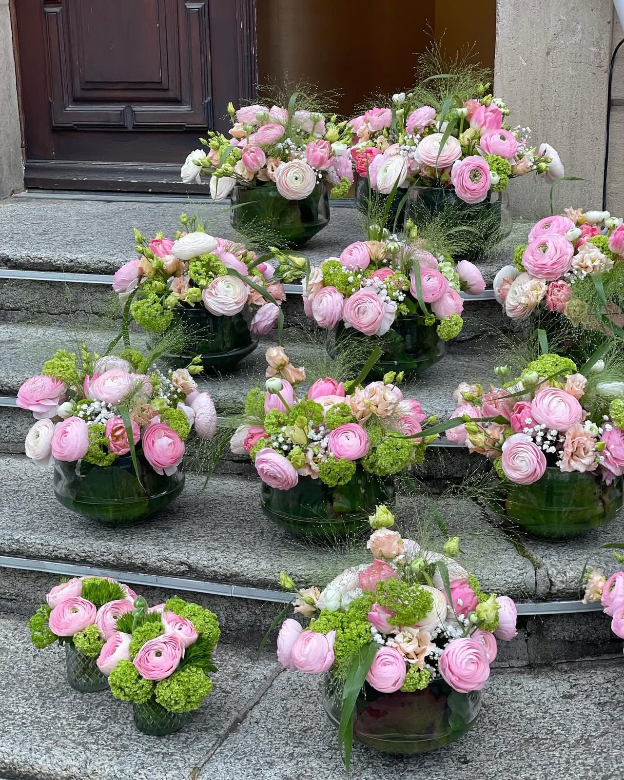 Petites compositions de renoncules roses sur des marches