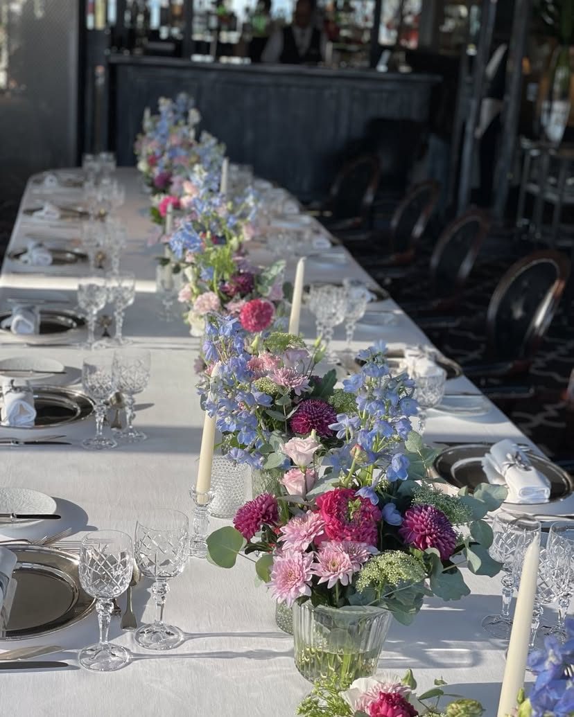 Longue table de banquet fleurie de compositions pastel