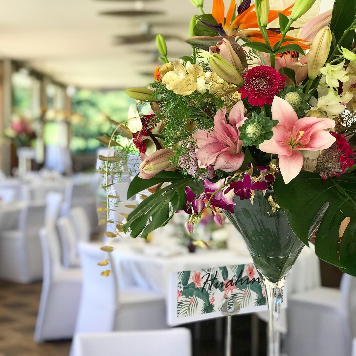 Grande composition de lys et de feuillages sur une table de mariage